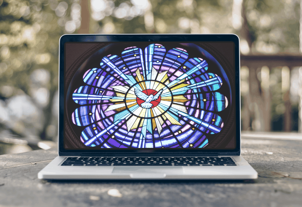 laptop computer with picture of dove in stained glass on the monitor