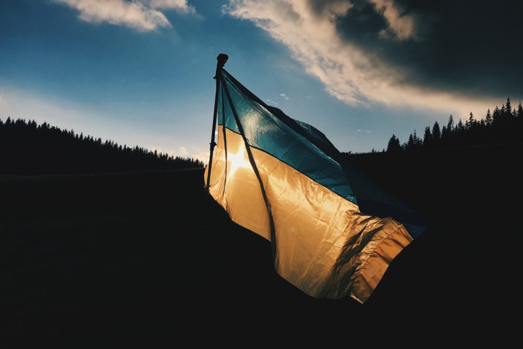 Blue and yellow striped Ukrainian flag at sunset